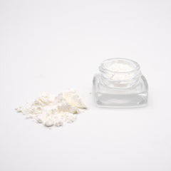 Clear glass cosmetic jar with loose white powder, featuring Oregon hemp CBD Isolate